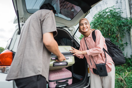 muslim couple packing suitcase in the car trunk for eid mubarak holidayの写真素材