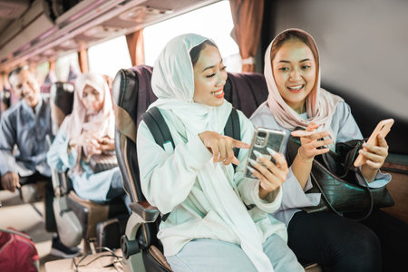 happy muslim woman using phone while travel by bus during eid mubarak holidayの写真素材