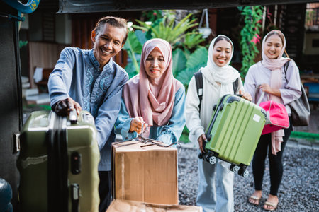 happy asian muslim passengers with their parent traveling by bus. portrait of family are putting suitcases into bus trunk baggageの写真素材