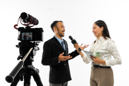 one set of standing camera recording a beautiful journalist in white blouse interviewing an adult men in black suitの写真素材