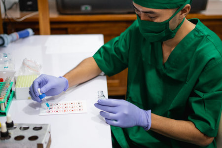Doctor in sterile uniform drips diagnostic serum onto blood type paper in the lab