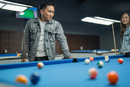 male pool player looking at the balls on the pool seriously