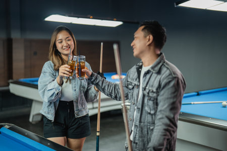 couple of asian people toasting during the break of the pool gameの写真素材