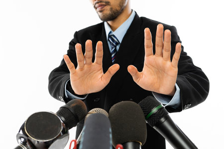 different types of microphone pointed at an adult man in blue shirt and black suitの写真素材