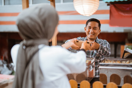 man sells various kinds of dumpling food with a cart on the side of the roadの写真素材