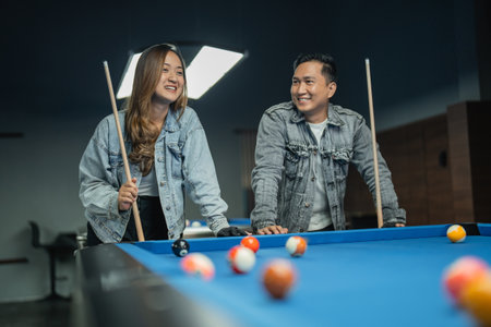 portrait a couple of player smiling while chatting during the break of the billiard gameの写真素材