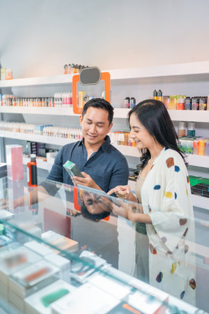 couple of vape seller checking the availability of the vape mod stock on the digital tabletの写真素材