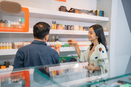 couple of shopkeeper checking the stock of the liquids using the digital tabletの写真素材
