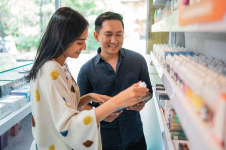 couple of shopkeeper observing the liquid together using the digital tabletの写真素材