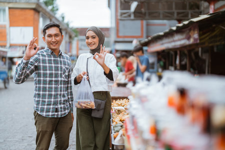 beautiful muslim couple are shopping in a food stall or street vendor during ramadanの写真素材