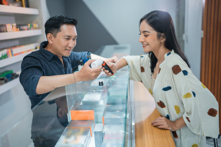 female customer with long black hair choosing the variant of the vape mod that offered by the male sellerの写真素材