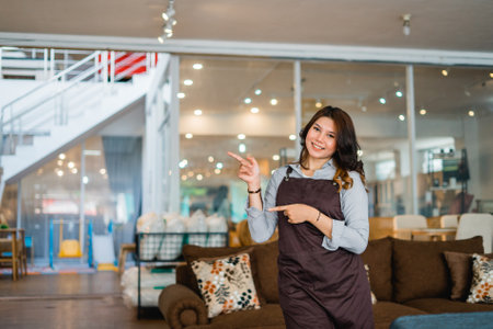woman attracting a shop assistant with a hand gesture offering something standing in a furniture storeの写真素材