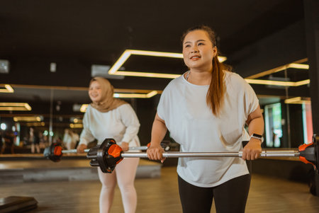 happy asian women following fitness class in indoor gym