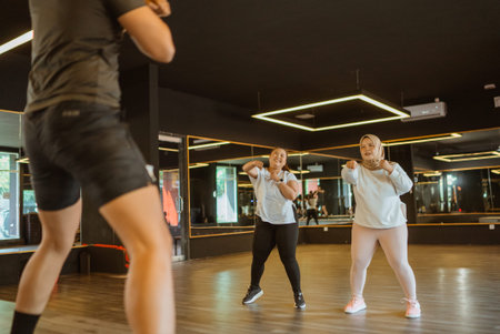 asian woman following sports class together with friend