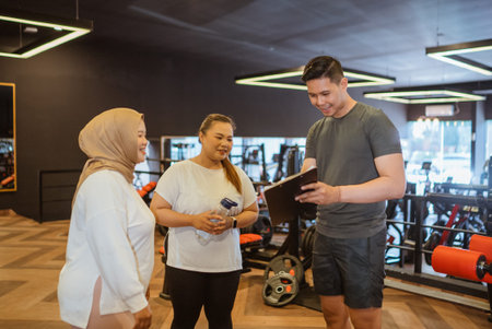 asian male fitness coach explain something to his trainee