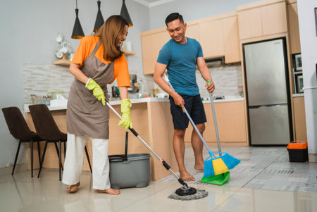 asian couple sweeping and mopping dinning room floor