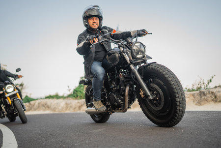 asian motorcylist on jacket and helmet traveling with slow speedの写真素材