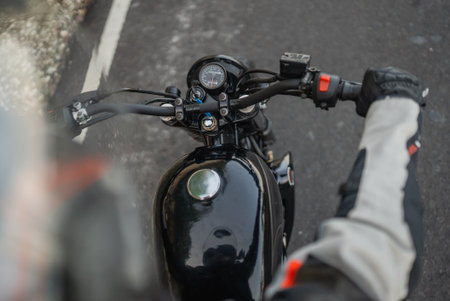 cropped view of biker riding motorcycle on the asphalt roadの写真素材