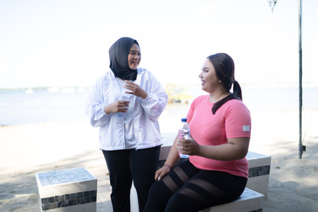 asian sporty women taking rest and drinking mineral waterの写真素材