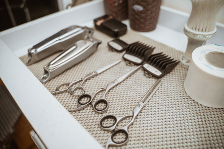 a set of barber equipment arranged on a table, shaver, scissor, blade, clipper