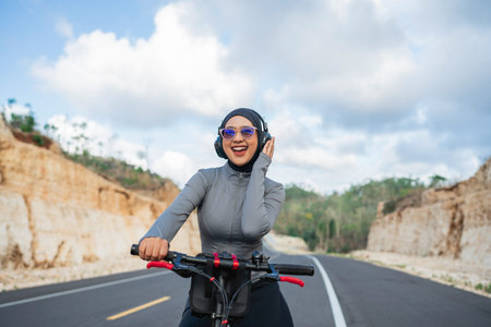 joyful woman listening to some music when biking on the hill