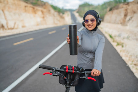 hijab woman holding bottle water with blurred background, selective focusの写真素材