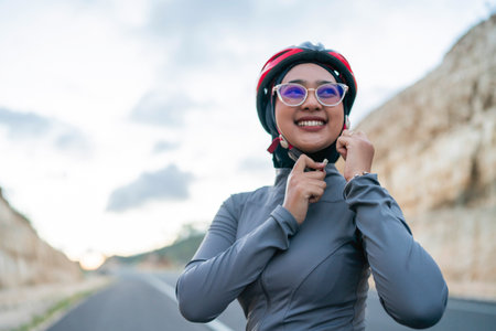 woman putting on helmet, safety riding, half body portraitの写真素材