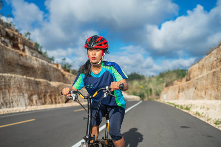 female cyclist wearing helmet riding mountain bike, healthy lifestyle, leisure activityの写真素材