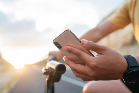 close up male biker hand wearing smartwatch and holding phone, copy space photo