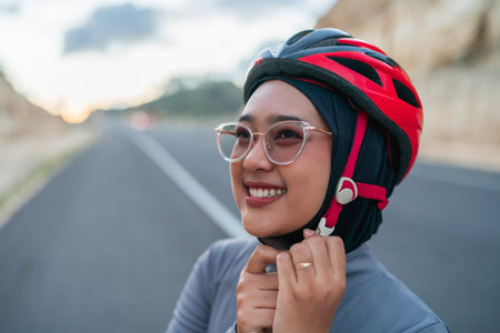 close up hijab biker wearing helmet for safety riding bikeの写真素材