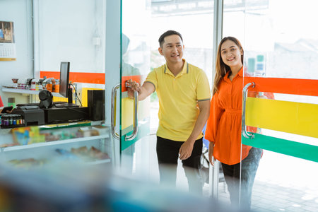 husband and wife open the glass door when they come to shop