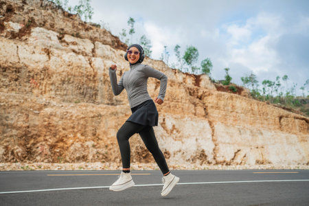 happy woman running wearing hijab and sportswear, jogging conceptの写真素材