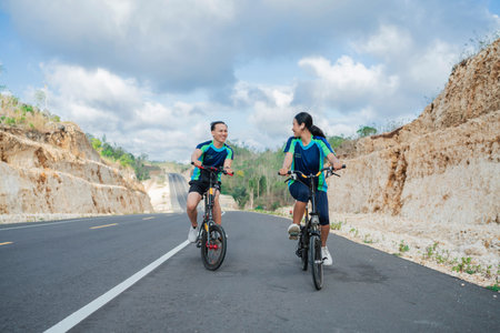 Asian couple biking together on the hill, healthy lifestyle, leisure activity, biking conceptの写真素材
