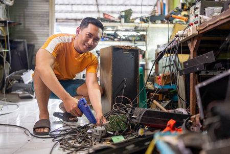 Asian man smiling technician repairing dynamo while working at service station