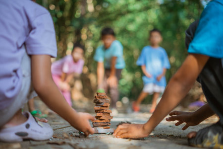 close up kids hand keeping stacked piece of rooftile, indonesian classic gamesの写真素材