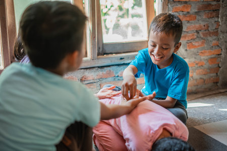 asian boy smiling while playing classic traditional indonesian gamesの写真素材