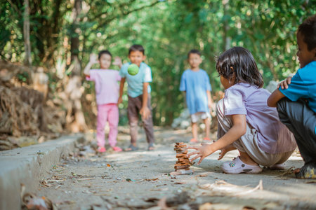 selective focus flying ball that throwed by indonesian kids when playing stacked traditional gamesの写真素材