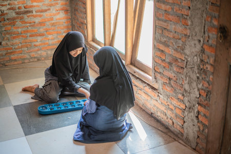 young hijab girls playing congklak indonesian traditional games indoorsの写真素材