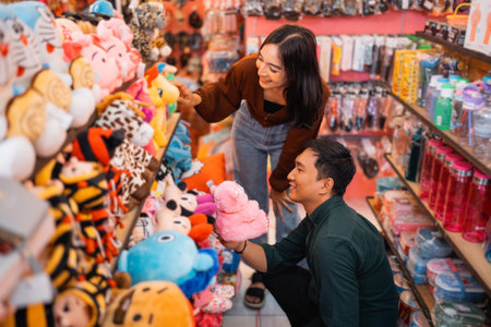 Young woman and handsome man choose dolls while shopping at an accessories storeの写真素材