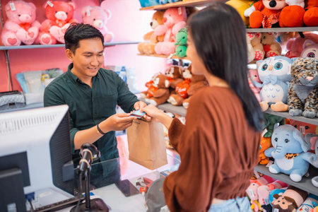 male waiter accepts credit card from female customer during payment at a store