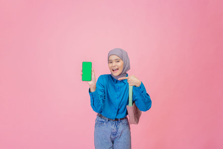 A cheerful young woman shows a vibrant green phone, dressed in a stylish outfit reflecting her