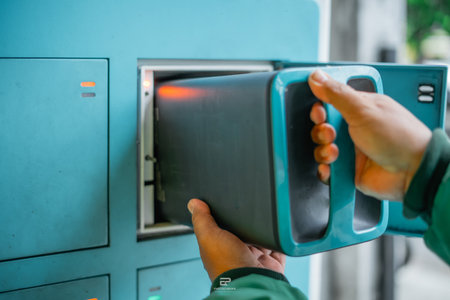 male hand pulling electric vehicle battery from swapping stationの写真素材