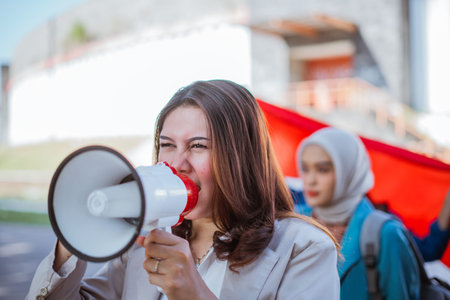 female student holding megaphone while leading a rally on indonesian independence day