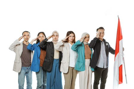 university students holding indonesian flag with salute gesture in isolated white backgroundの写真素材