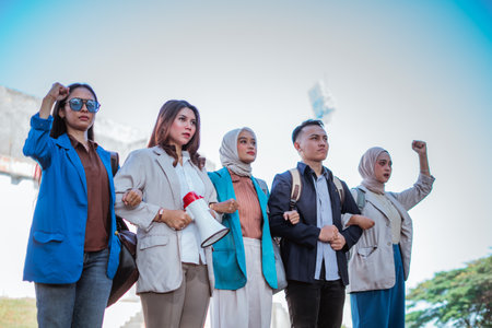 indonesian student standing and holding hands together with fist pump gestureの写真素材