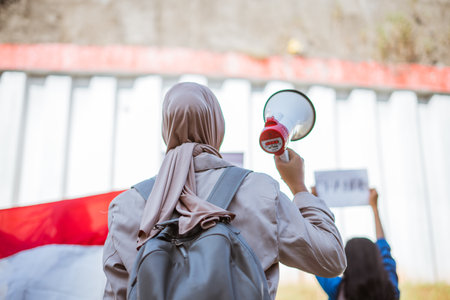An activist passionately holding a megaphone, advocating for change during a peaceful rally eventの写真素材