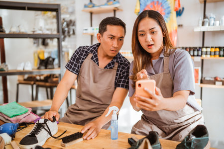 two asian workers shocked at something on the phoneの写真素材
