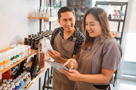 workers checking displayed products using tablet at shoes paint storeの写真素材