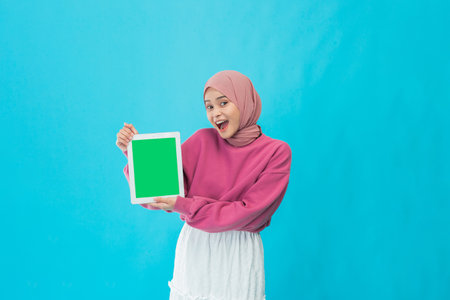 A joyful woman shows a vibrant green sign, ideal for promotional or advertising useの写真素材