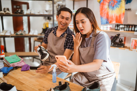 female worker surprised while watching something on the phoneの写真素材